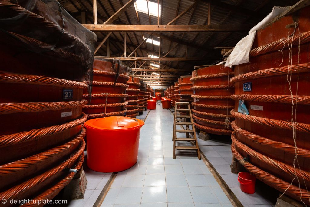 rows of huge wooden barrels inside Red Boat fish sauce factory in Phu Quoc, Vietnam