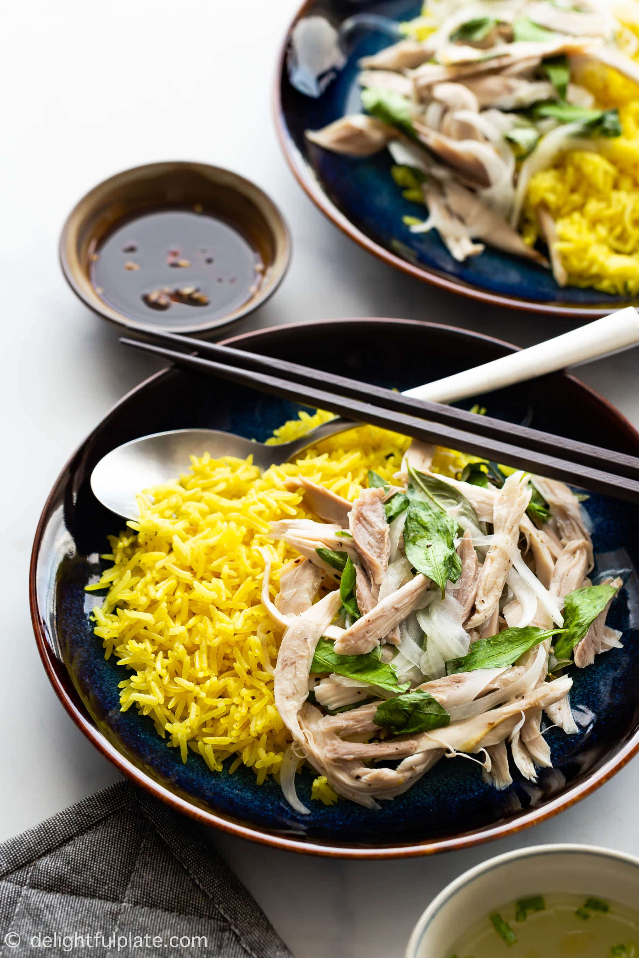 a plate of Vietnamese chicken rice (com ga Hoi An0 with a bowl of soup