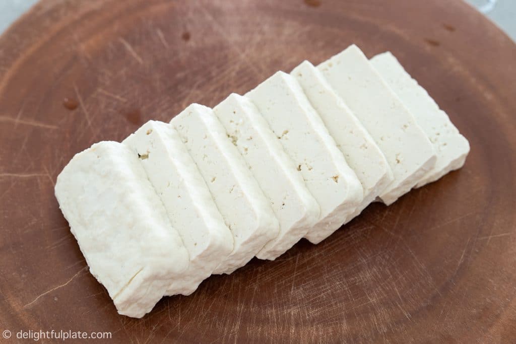 A block of tofu sliced into thin slices.