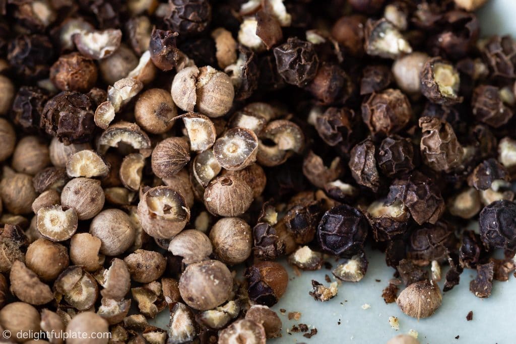 lightly cracked white and black peppercorns