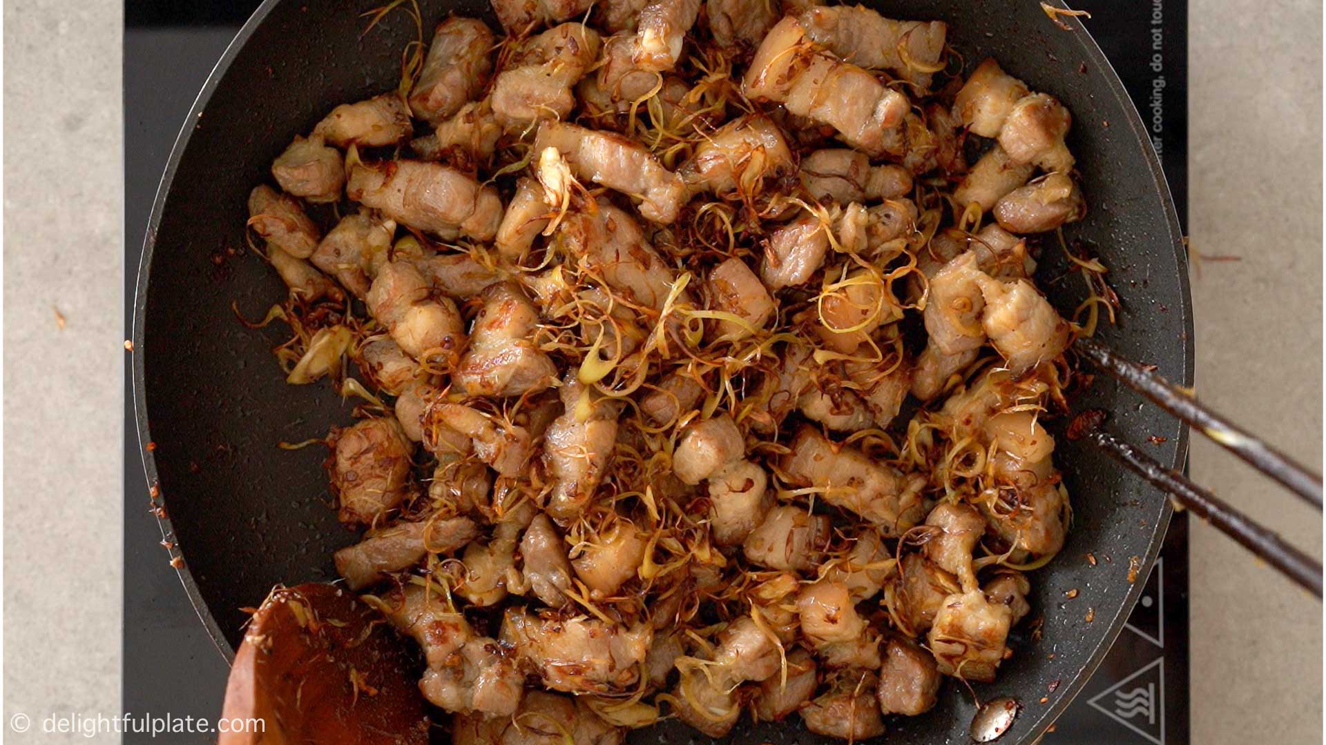 brown pork belly with lemongrass in a pan