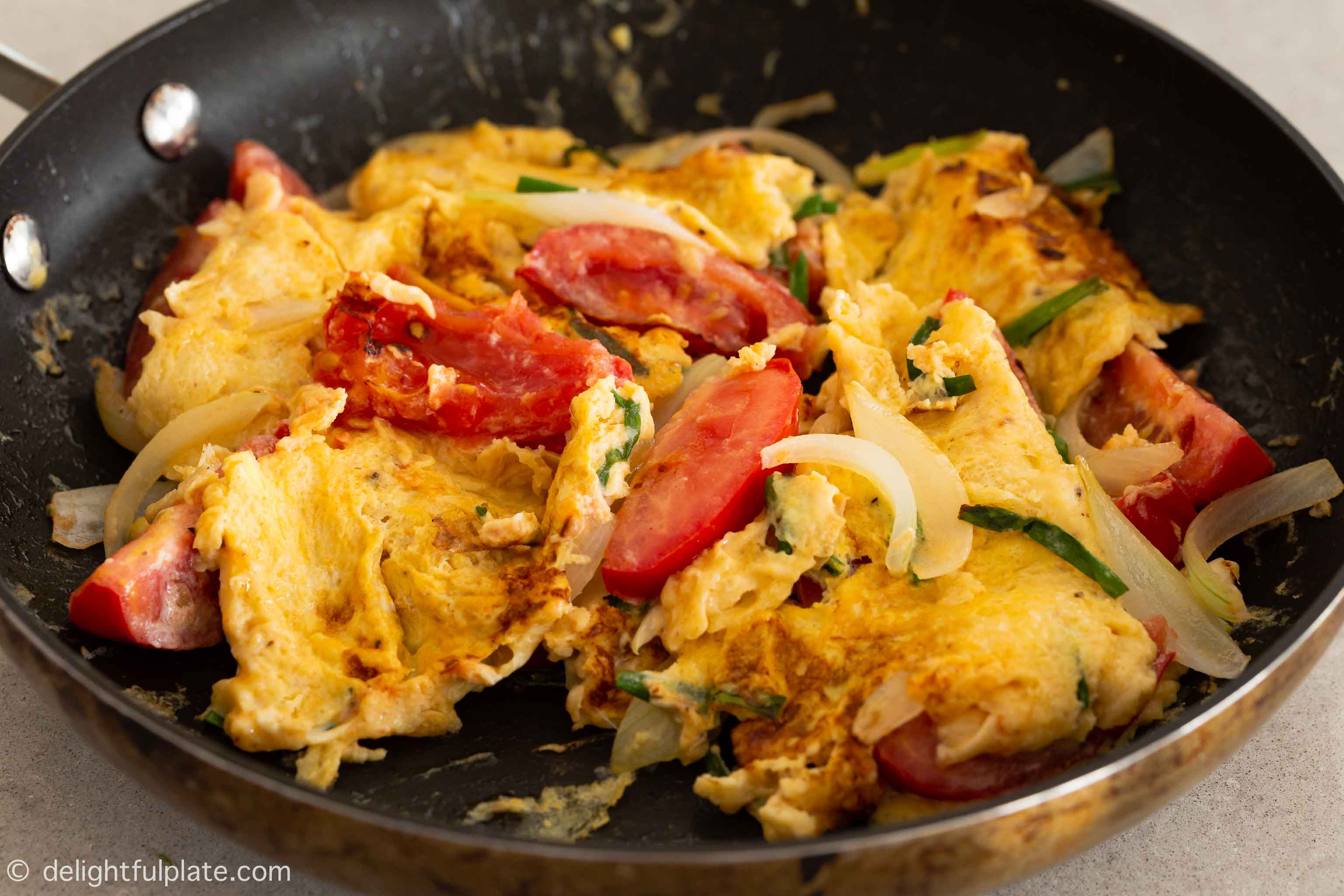 pan-fried eggs and tomatoes in a skillet