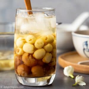 a serving glass with longan, lotus seeds soup and crushed ice