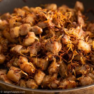 pieces of pork belly that have been cooked with lemongrass in a pan