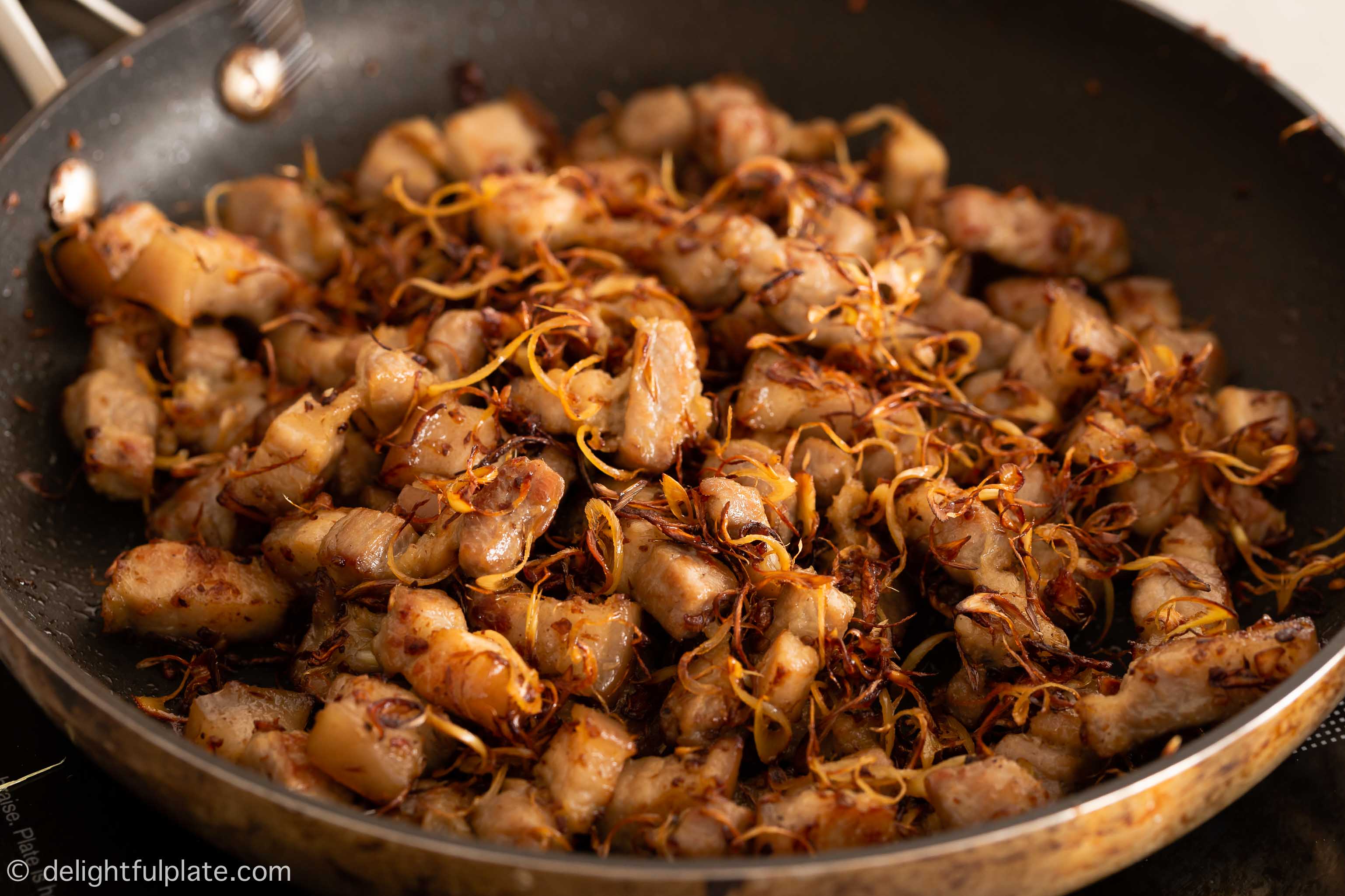 a pan with pieces of pork belly after being cooked with lemongrass.