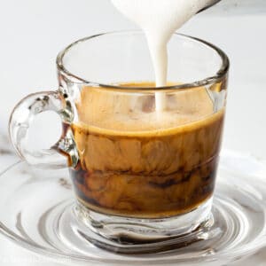pouring milk into ginger coffee