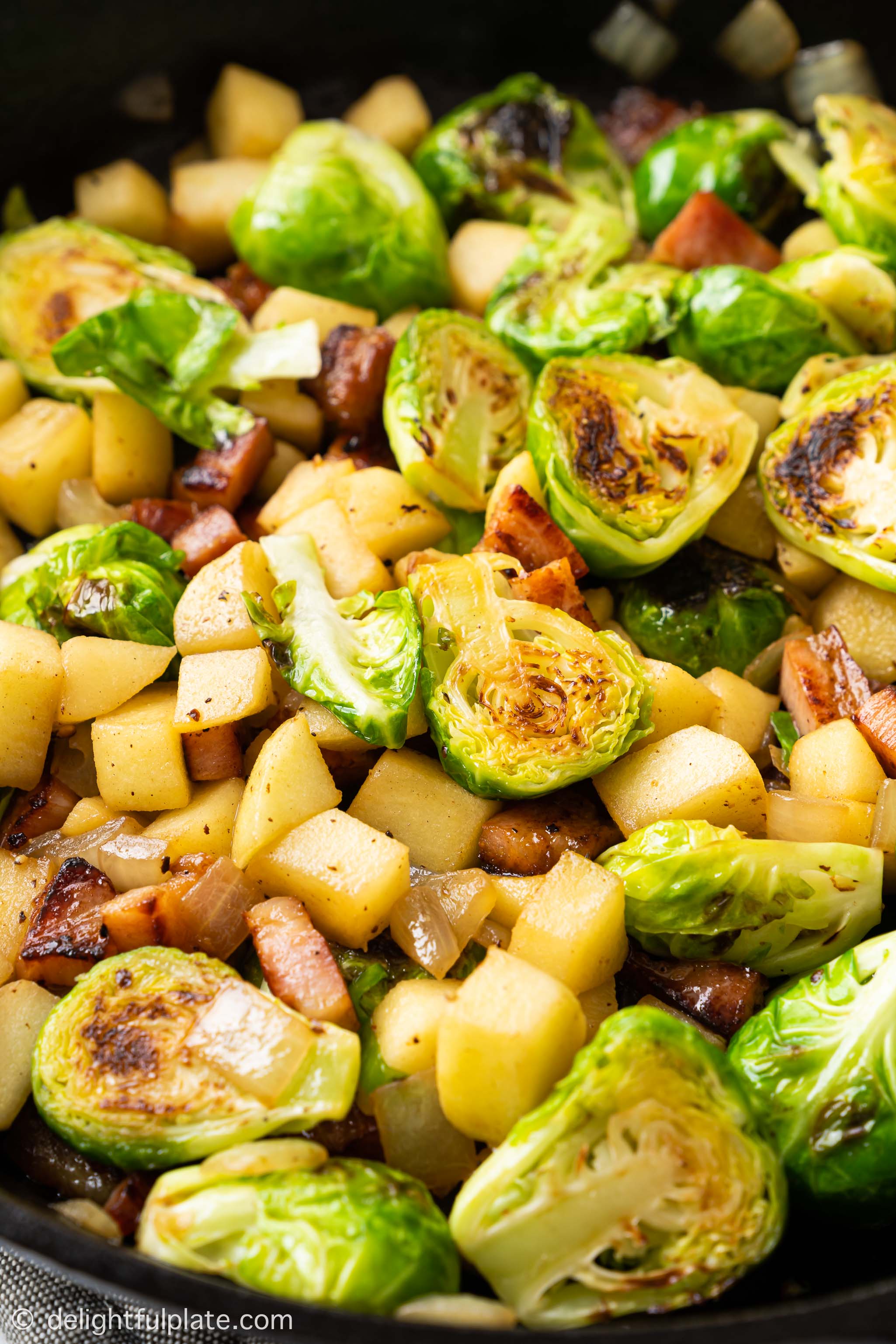Sautéed Brussels Sprouts with Bacon and Apple in a cast iron pan