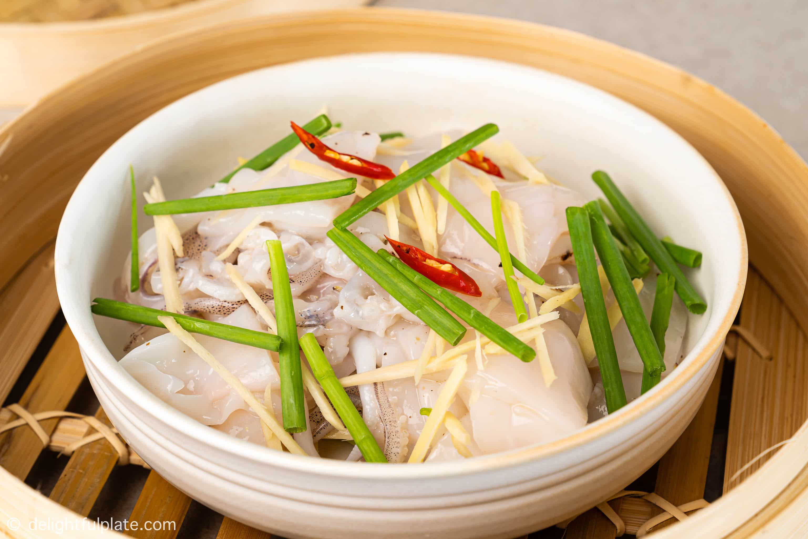 a bowl of squid slices inside a steamed basket