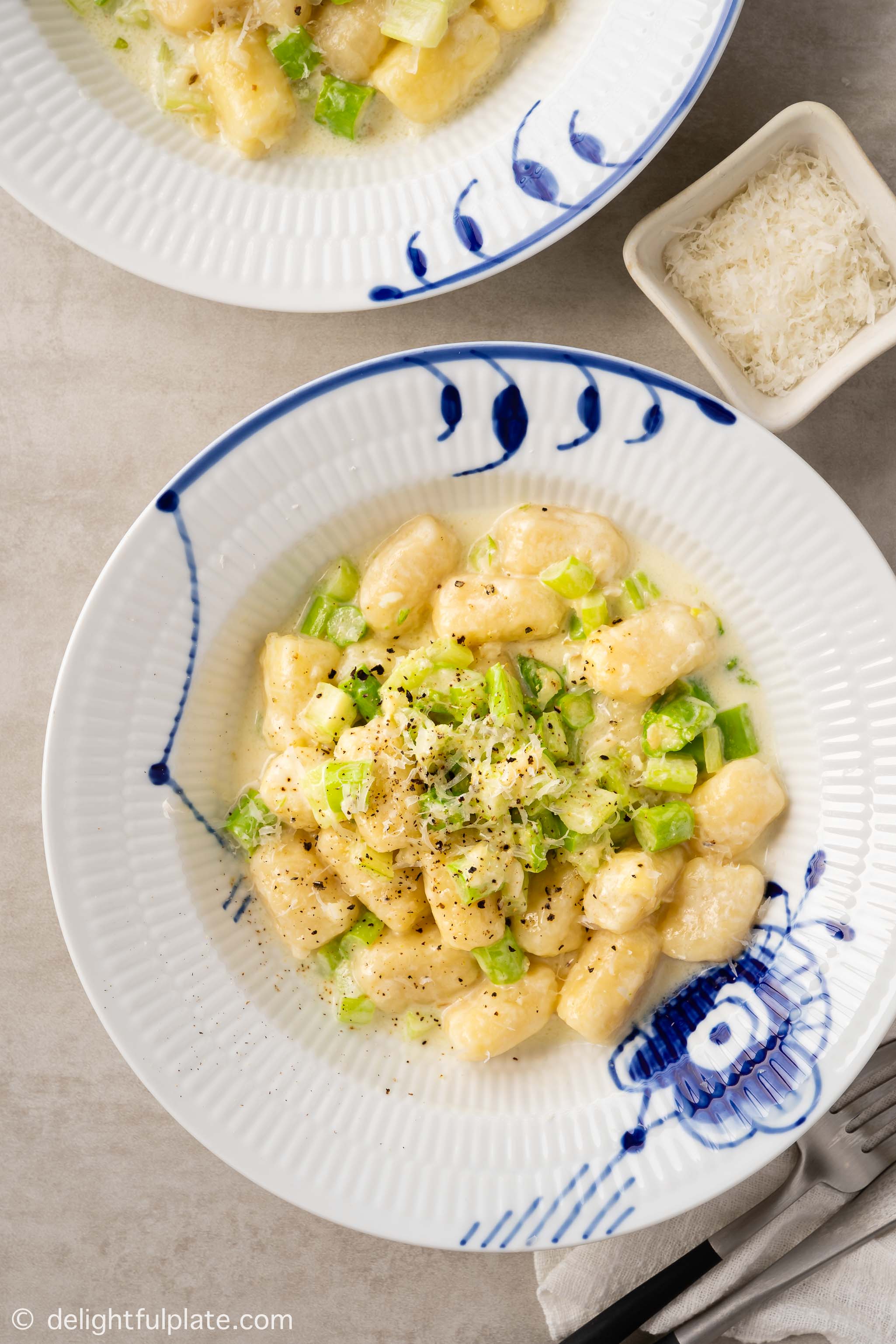 a plate of gnocchi and asparagus with cream sauce
