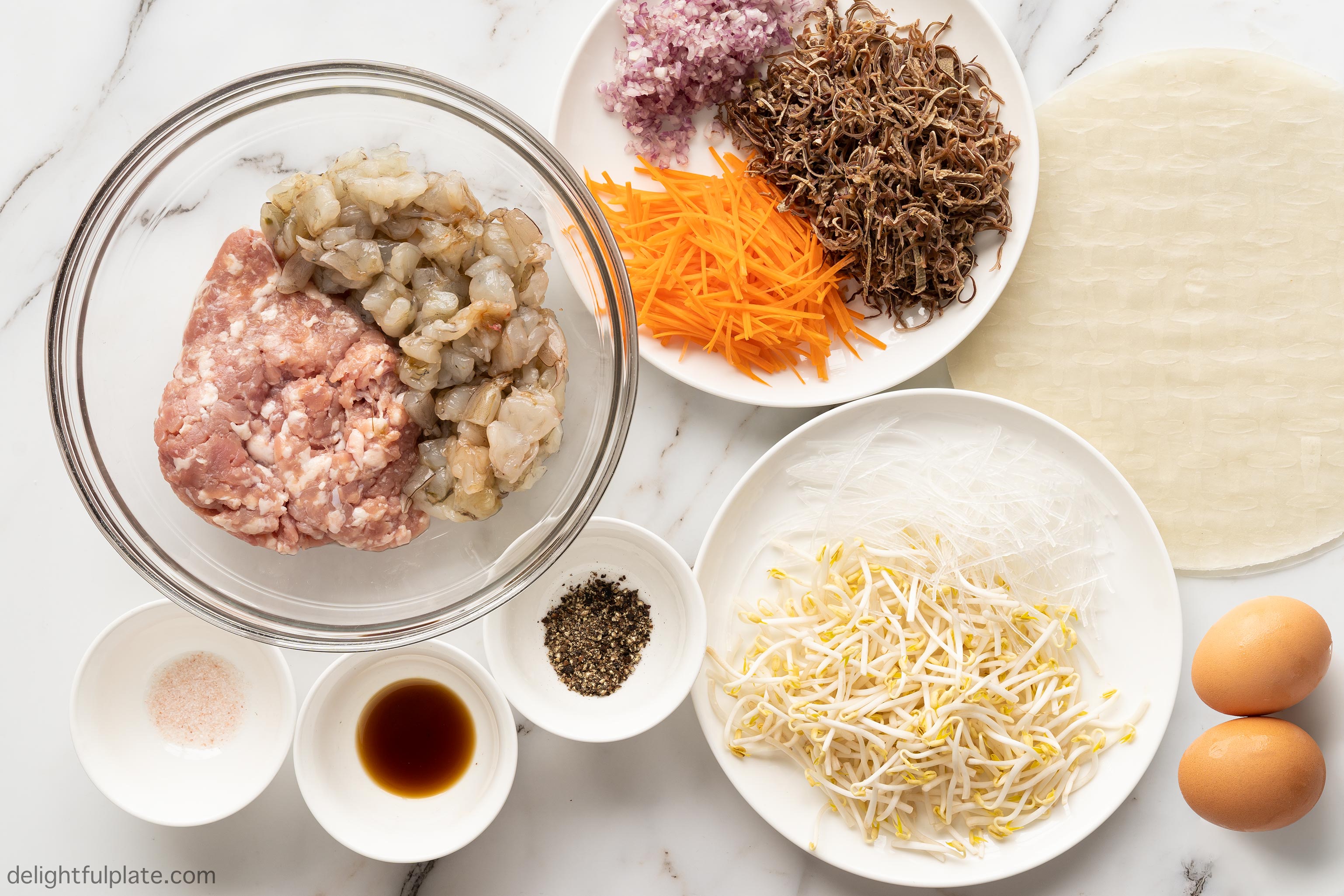 plates and bowls containing ingredients for spring roll filling