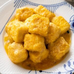 a plate of crispy silken tofu in salted egg yolk sauce