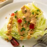 a wedge of iceberg lettuce served with peanut salad dressing