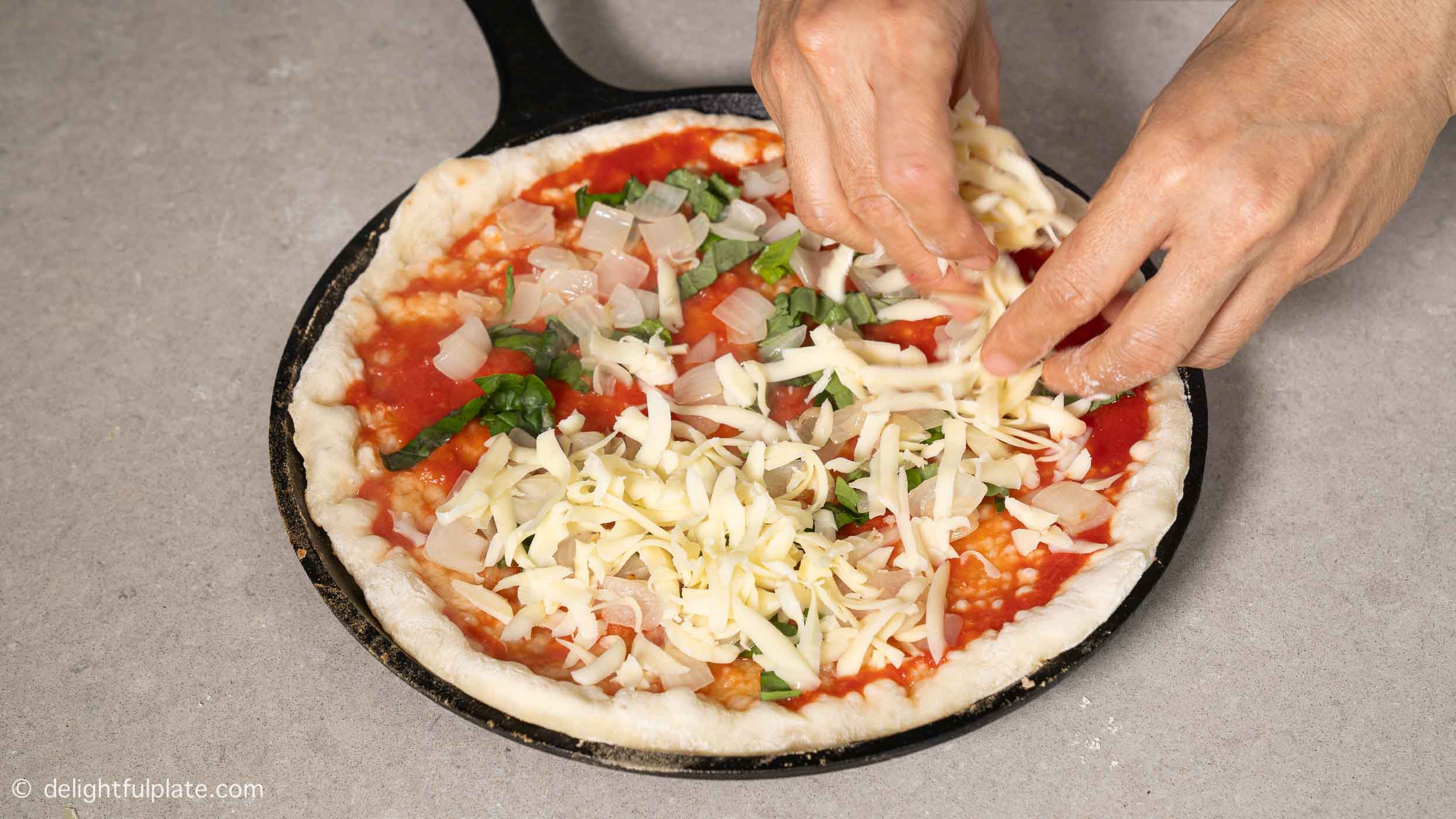 adding toppings on the pizza.