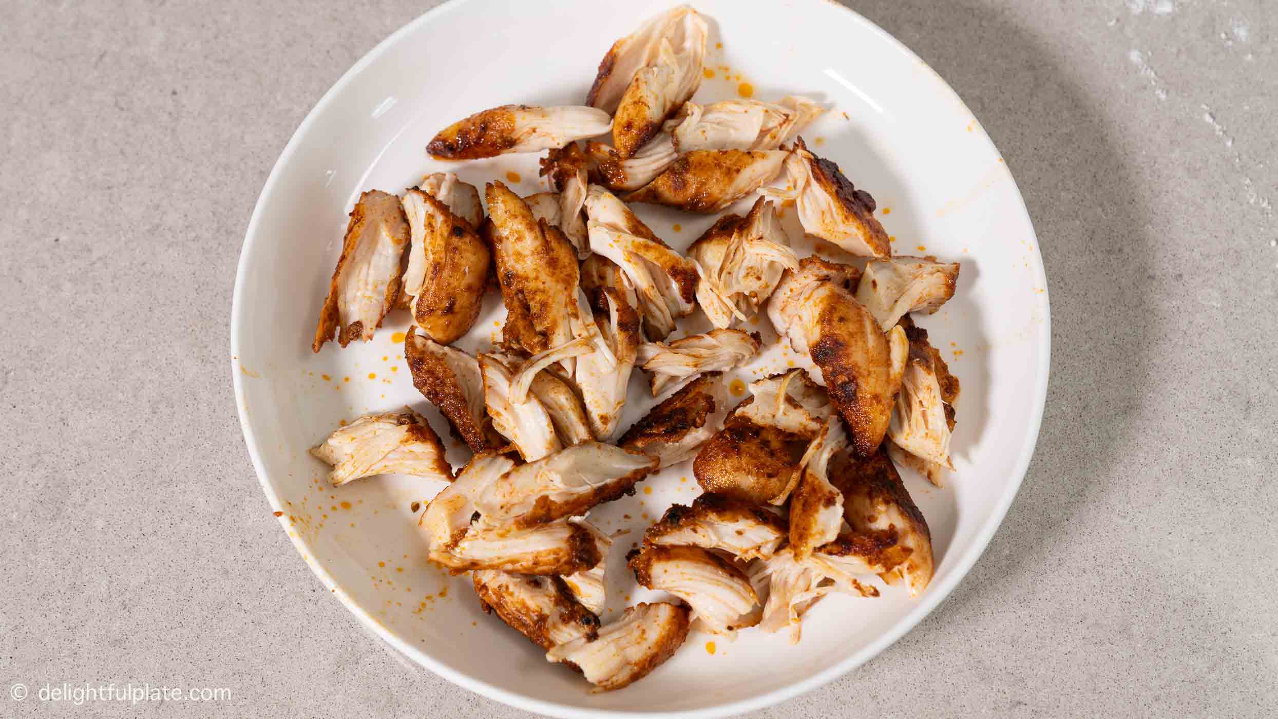 a bowl of shredded paprika chicken for pizza topping.