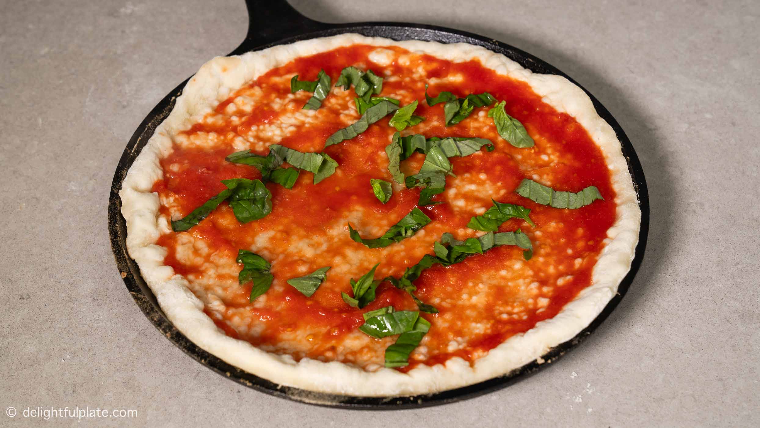 sprinkle a few basil leaves on the pizza base.