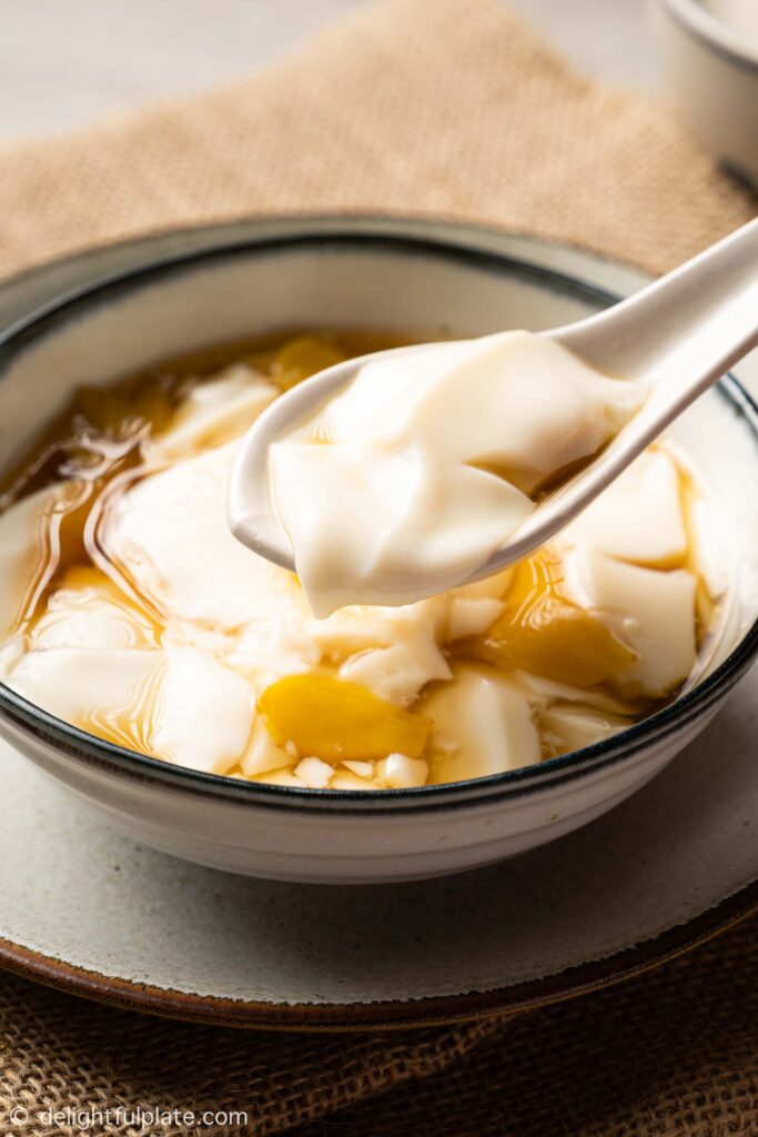 a bowl of tofu pudding with ginger syrup