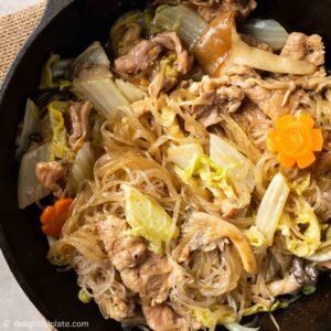 braised glass noodles with pork and napa cabbage in a wok