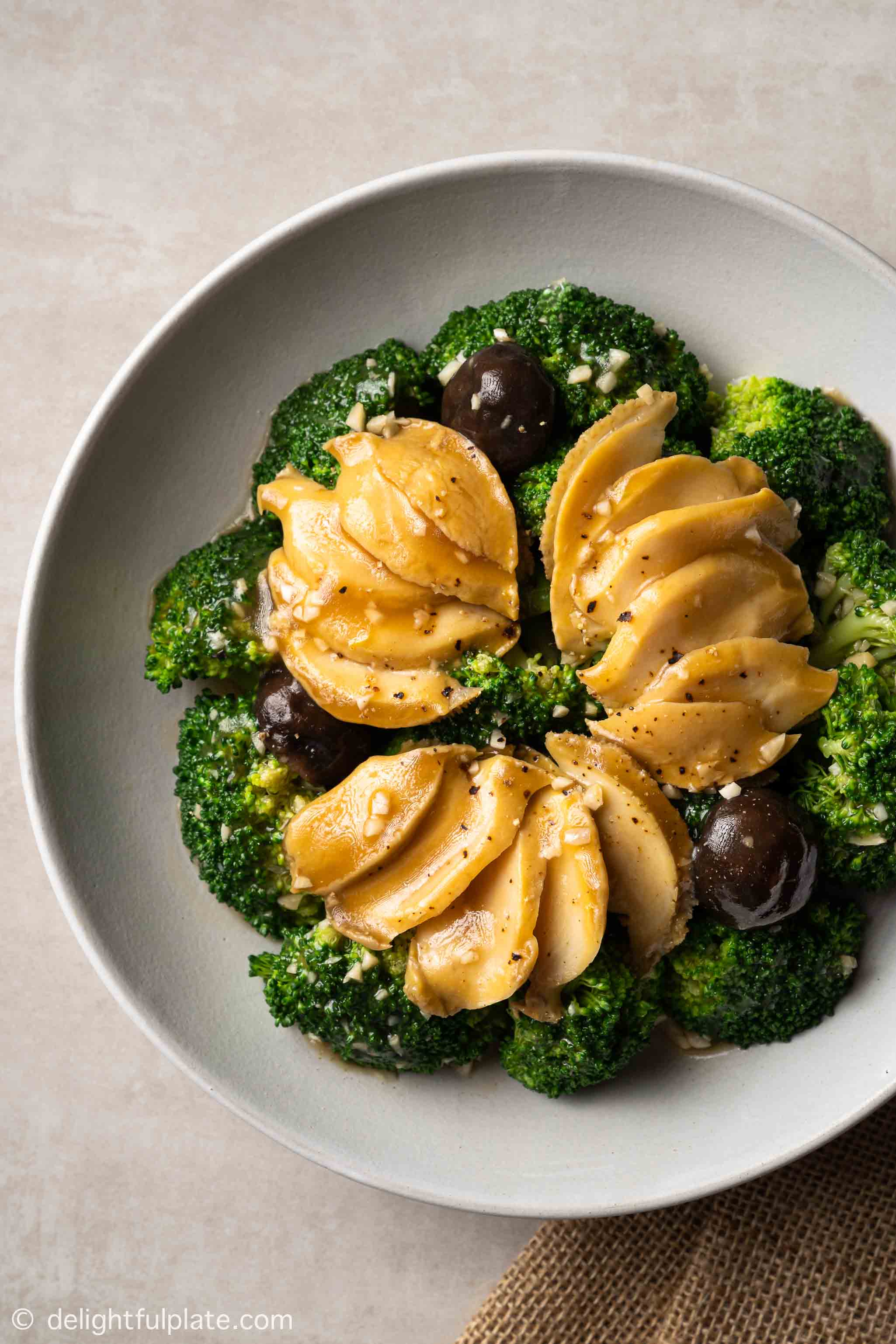 a plate of braised abalone with broccoli in oyster sauce