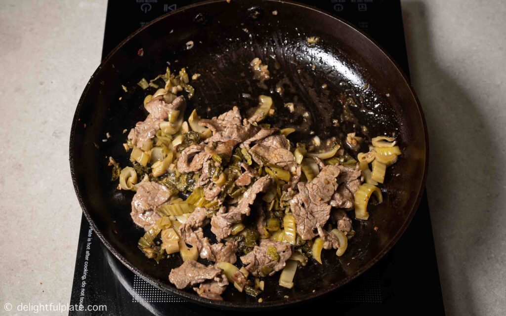 Sautéing beef with mustard greens