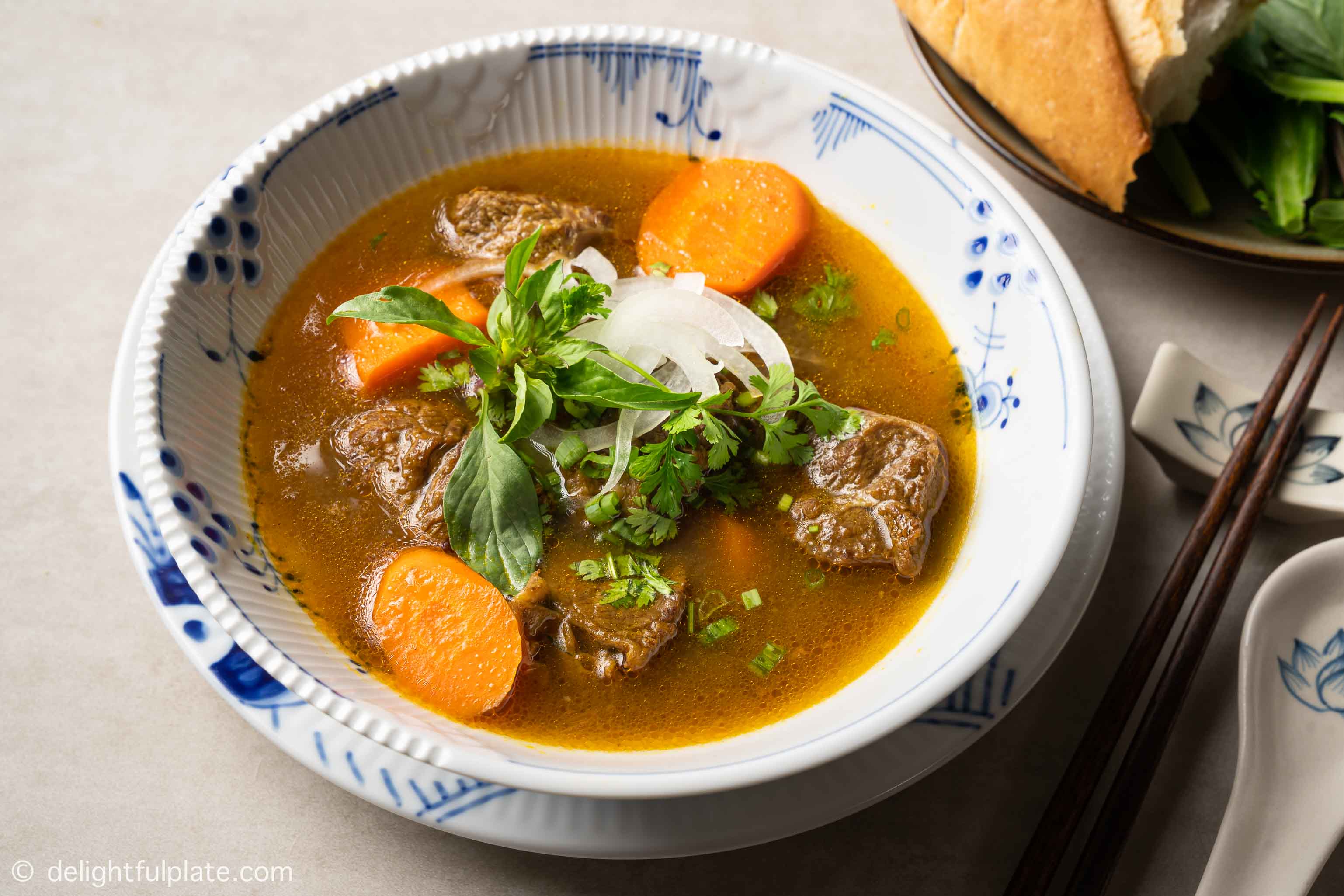 a bowl of Vietnamese beef stew (bo kho) served with bread