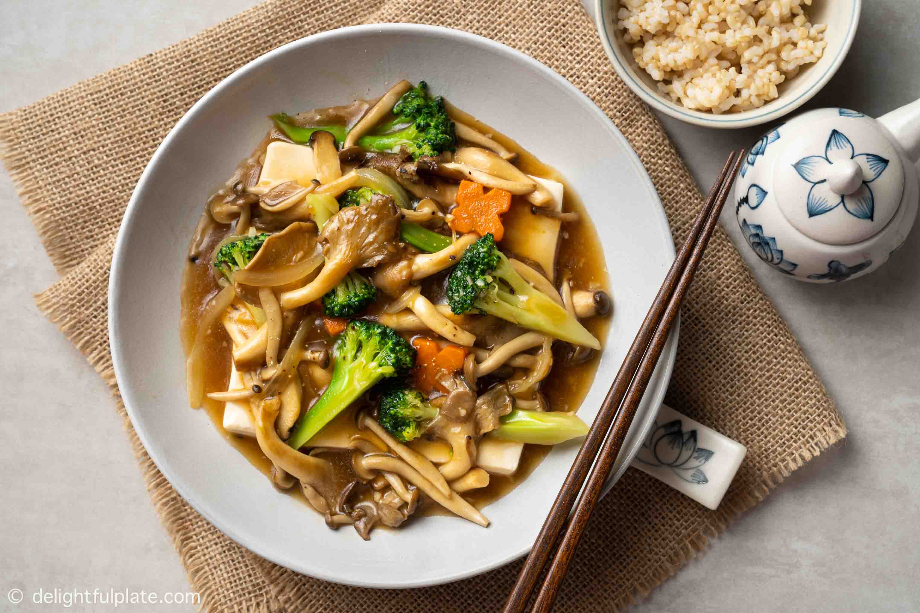 a plate of steamed tofu with vegetables and mushrooms in oyster sauce