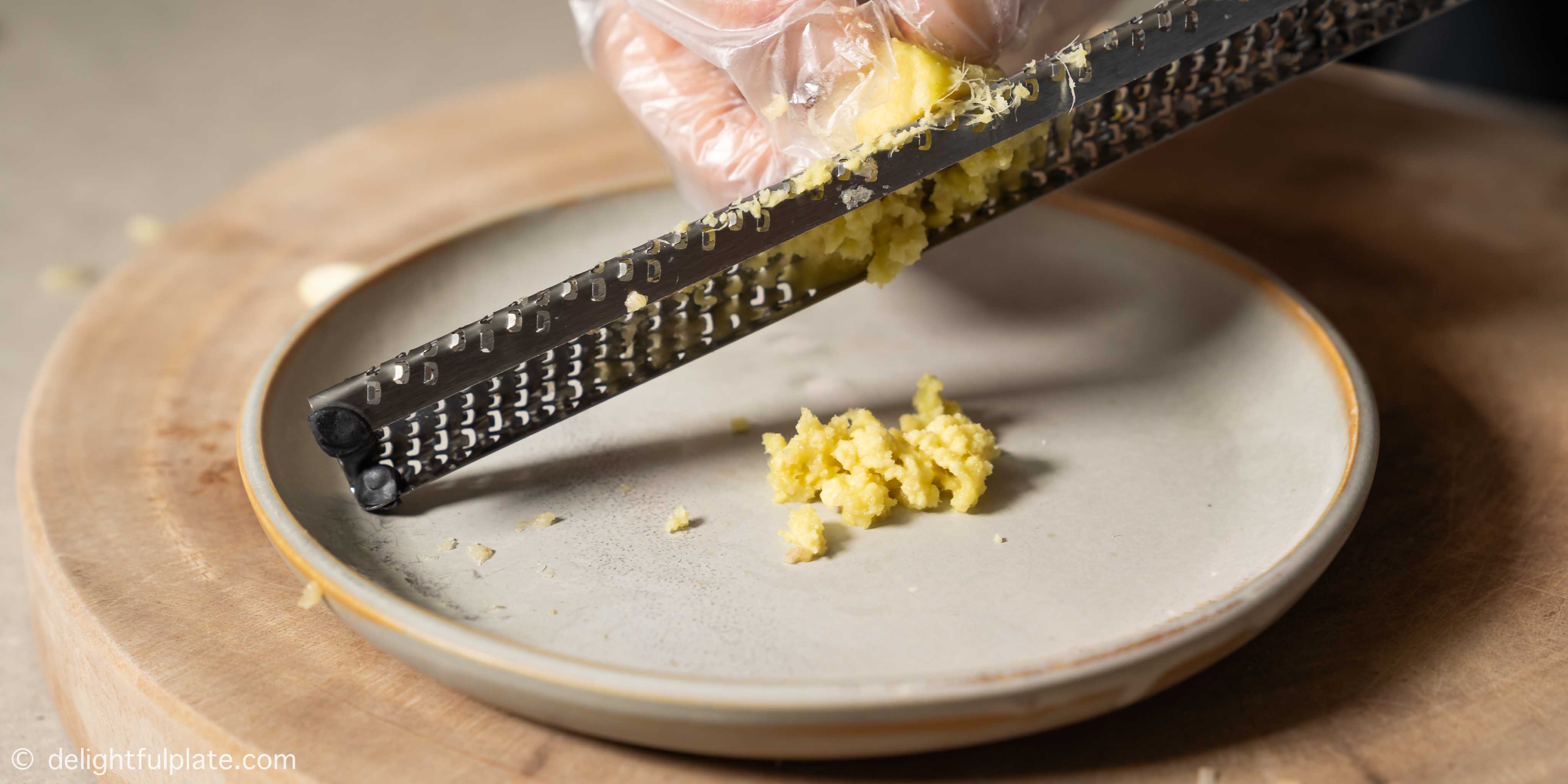 grating ginger over a plate