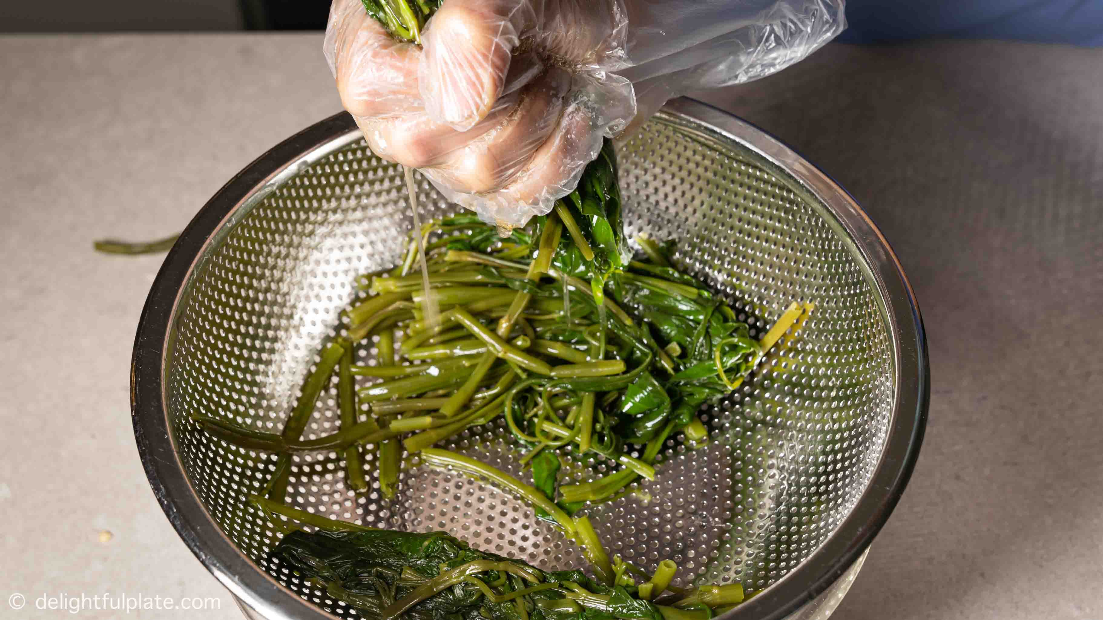 squeezing out excess water from the vegetable