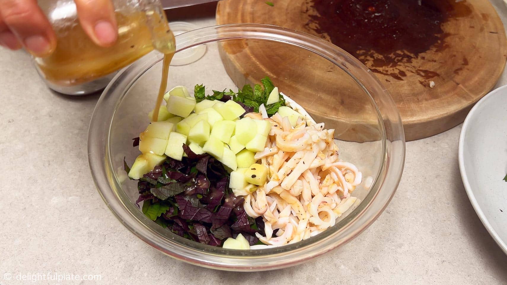tossing the ingredients with the dressing