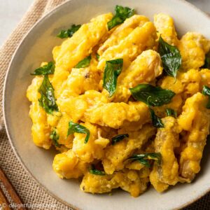 a plate of pumpkin fritters in salted egg sauce