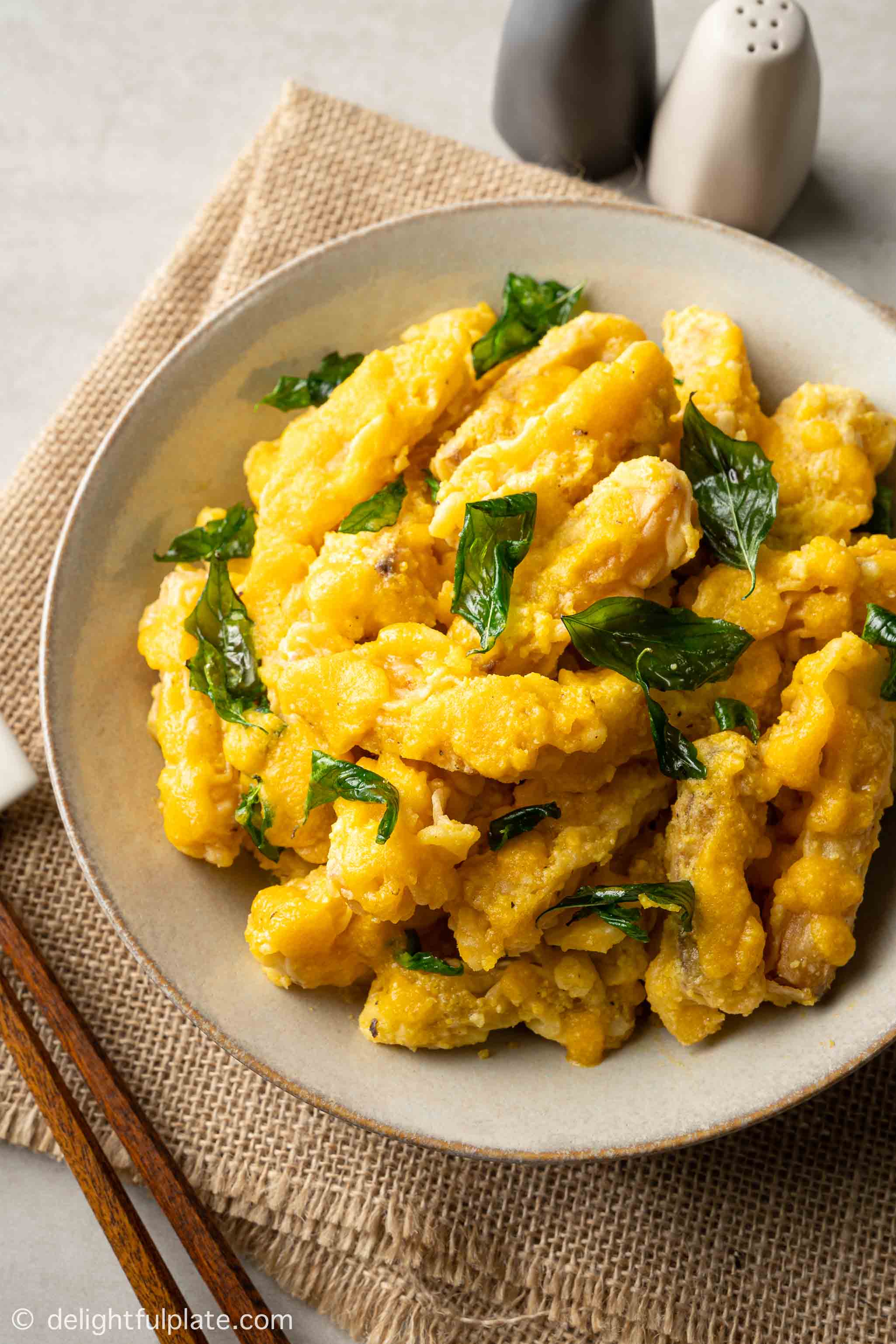 a plate of fried pumpkin fritters with salted egg sauce