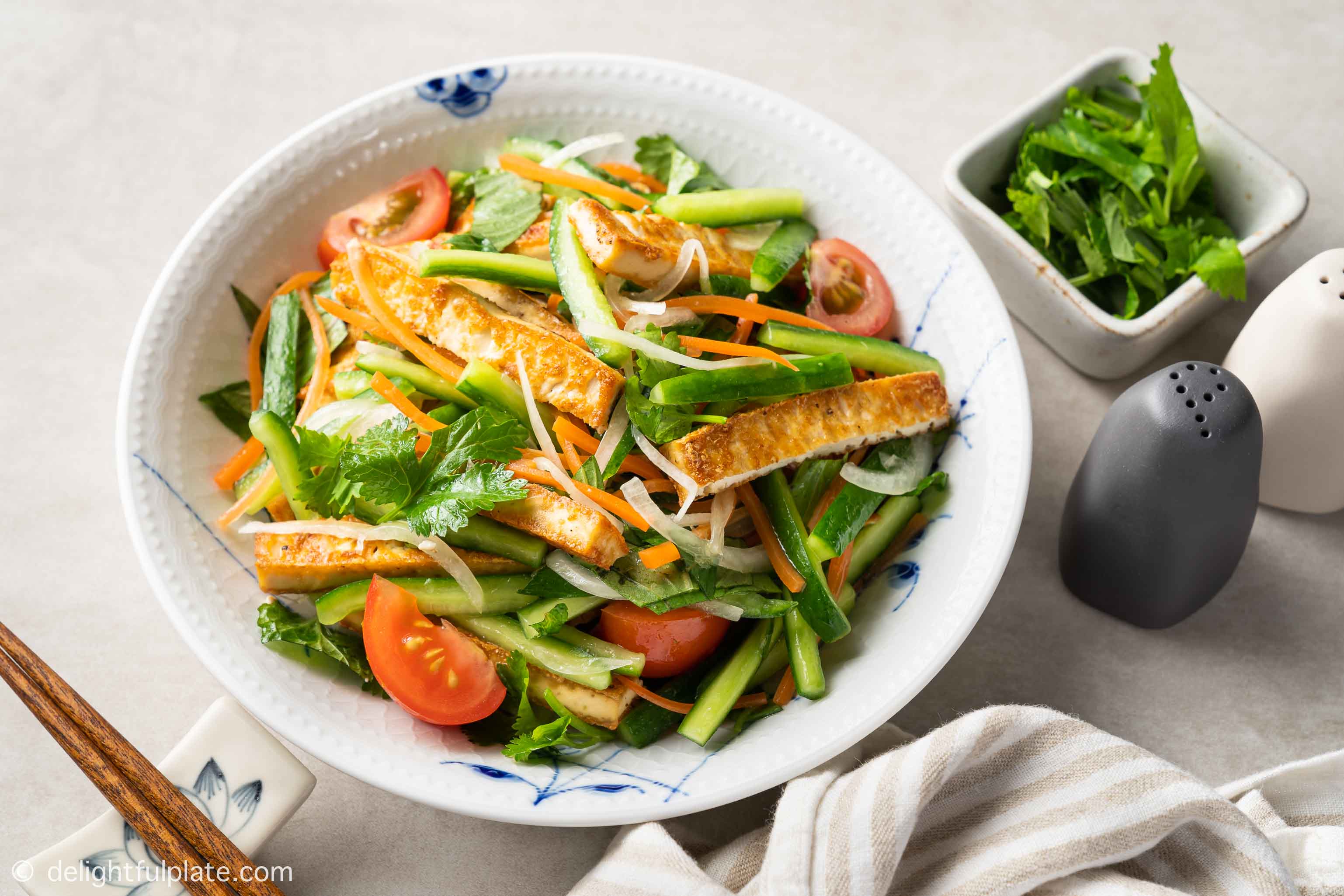 a plate of fried tofu salad with cucumber
