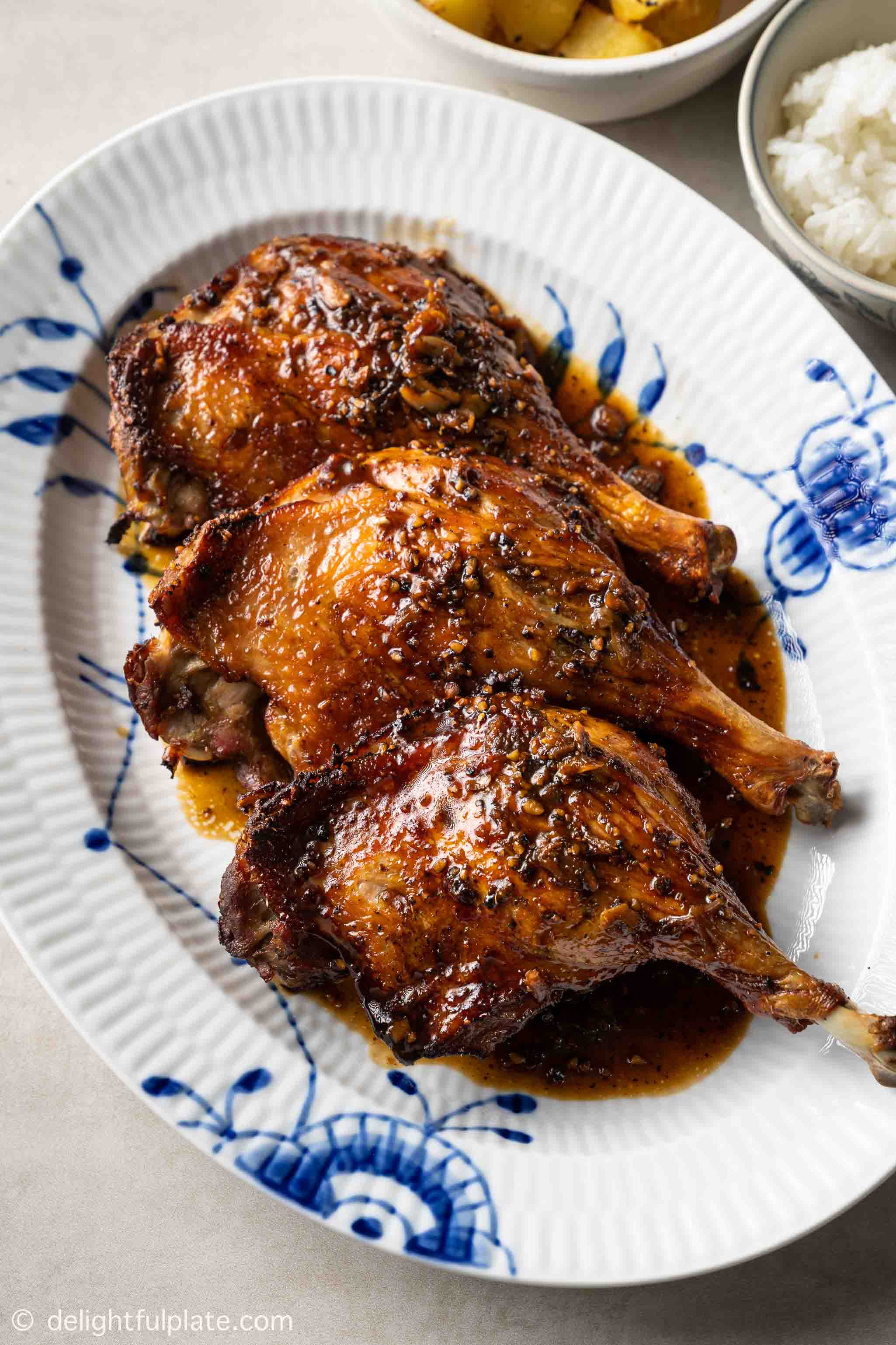 a plate of roasted duck legs with black pepper sauce