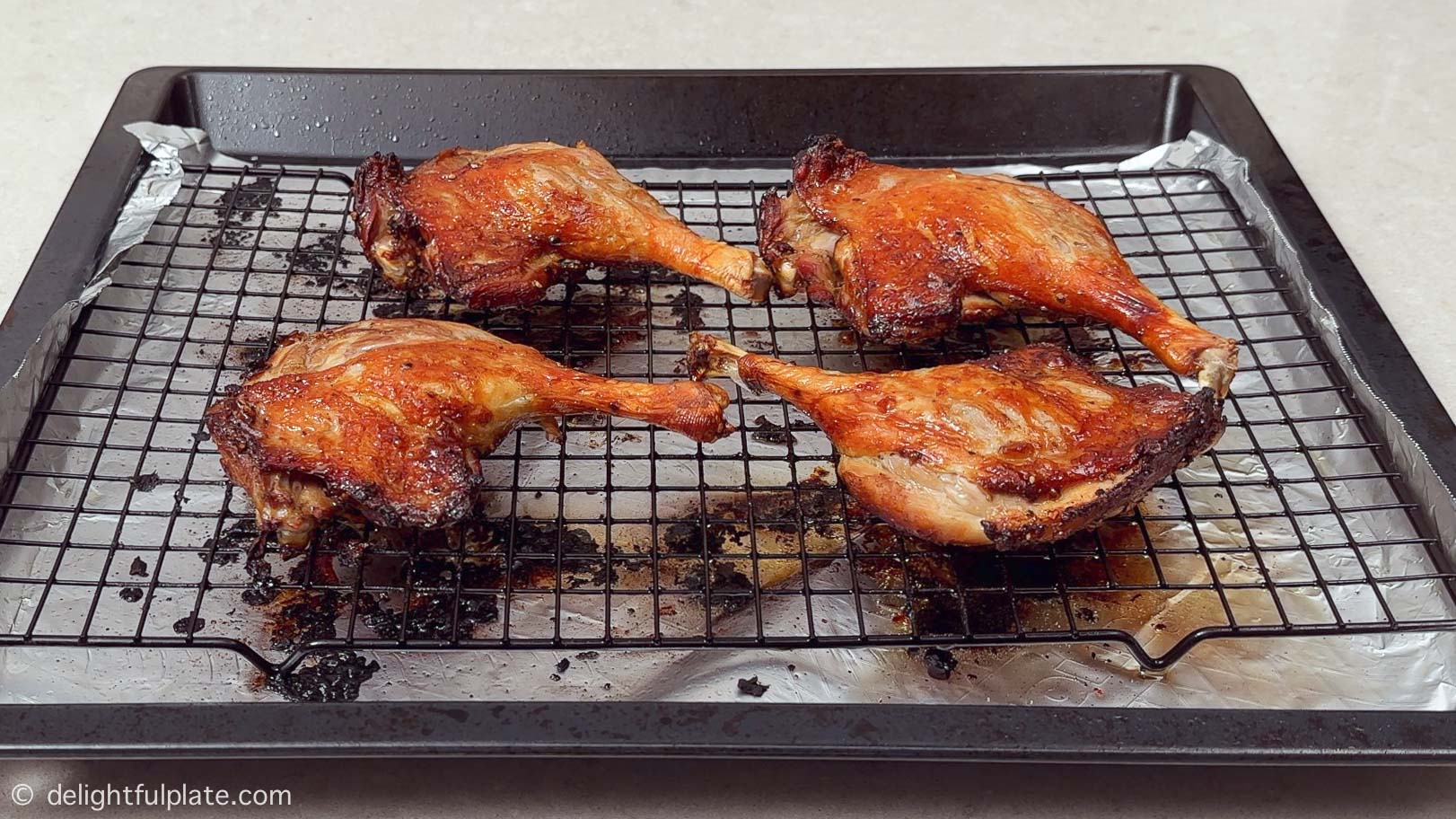 four roasted duck legs on the baking tray