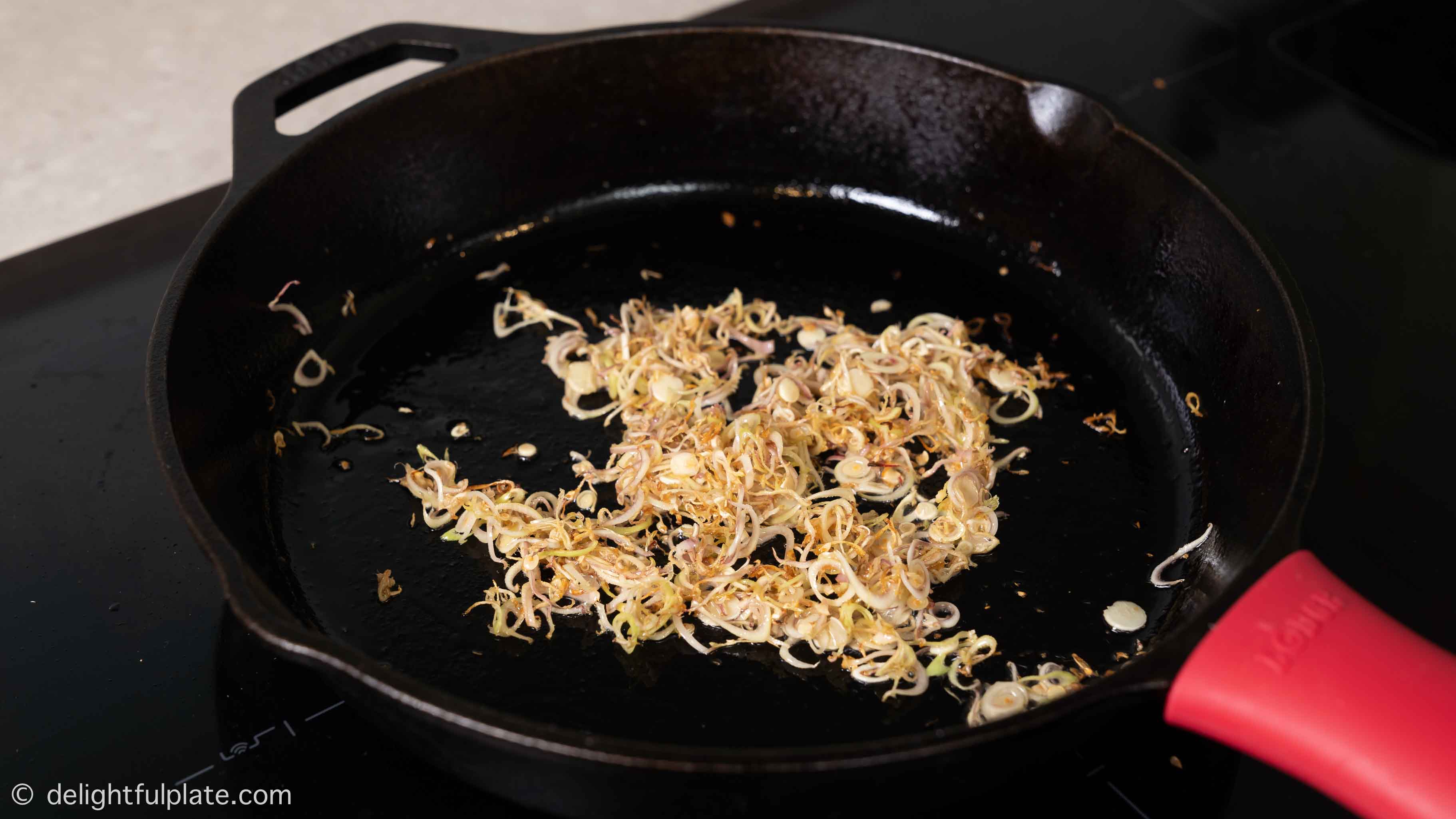 sautéing lemongrass in a cast iron skillet