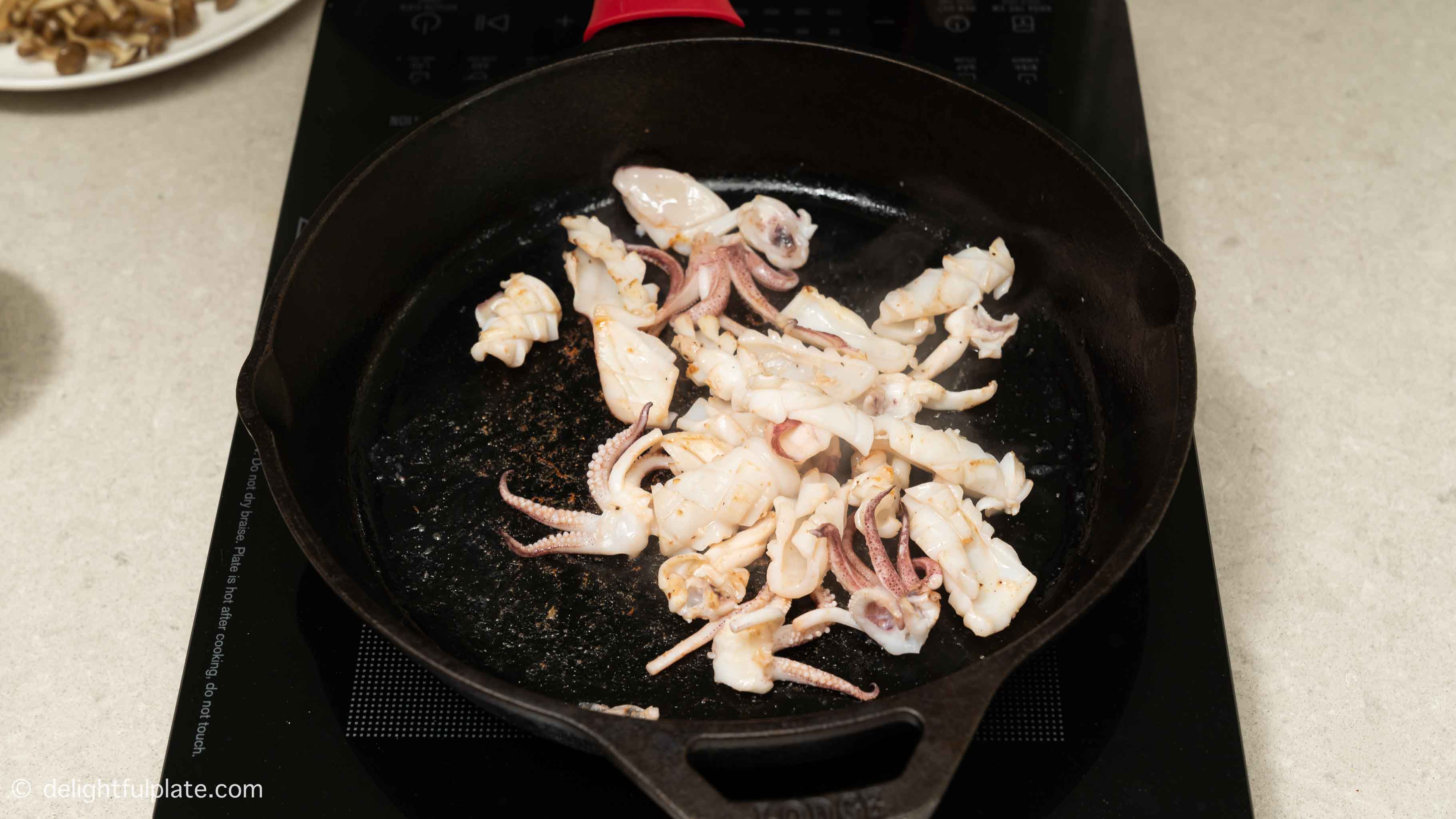 sear squid slices in a cast iron skillet.