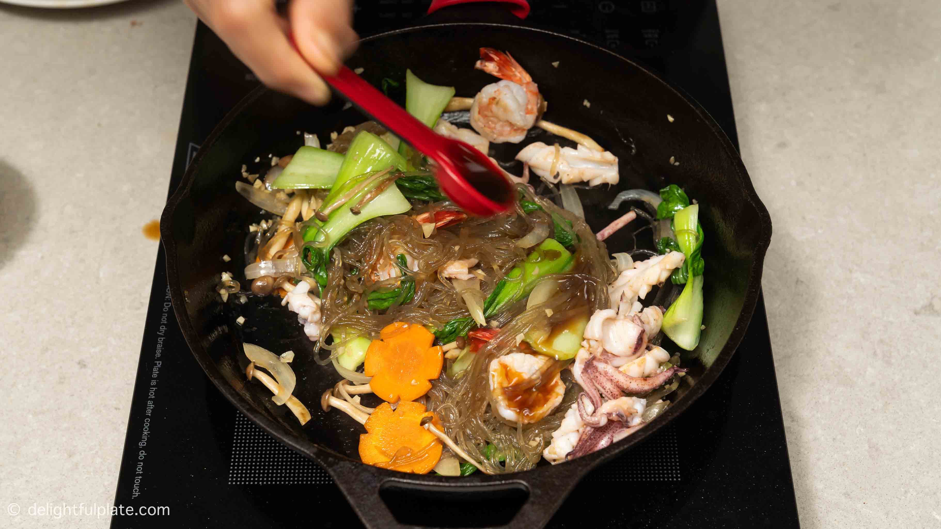 mix in the seafood with noodles and veggies.